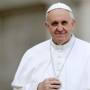El papa Francisco toca su crucifijo mientras lo conducen a través de la multitud durante su audiencia general inaugural, en la Plaza de San Pedro, en el Vaticano, el miércoles 27 de marzo de 2013. Francisco pidió el miércoles que se ponga fin a la violencia y los saqueos relacionados con el golpe de estado del fin de semana en la República Centroafricana, en su primera apelación de ese tipo por la paz desde que se convirtió en papa. (AP foto/Andrew Medichini)